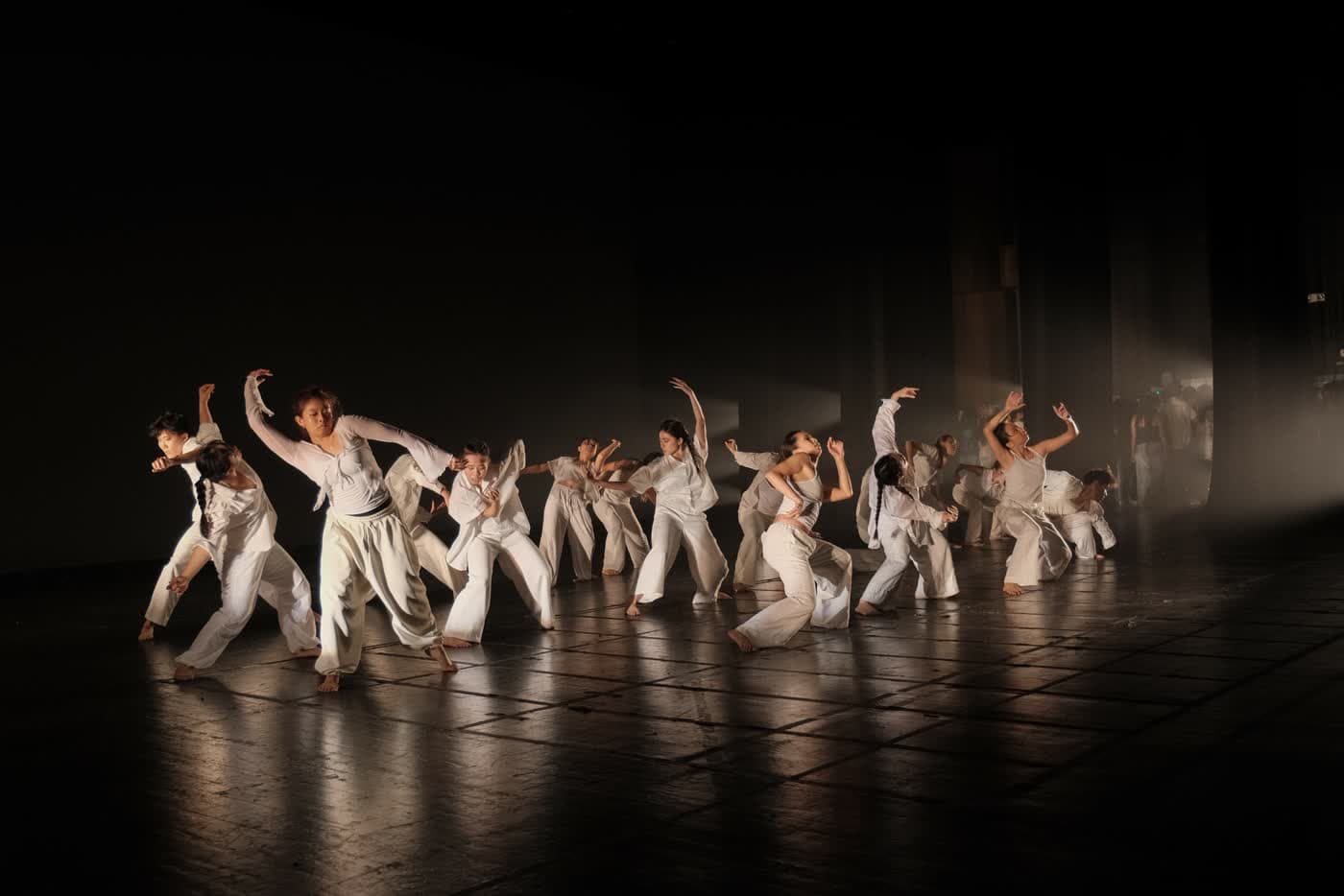 Dancers mid-performance on a dark stage